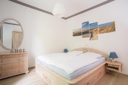 sypialnia z łóżkiem i lustrem w obiekcie Wohnung Waldkauz im Haus Seeadler w Zinnowitz