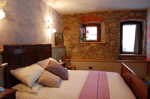 a bedroom with a bed and a stone wall at il mondo in valle in Pessinetto