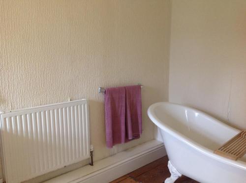 a bathroom with a white tub and a purple towel at The Gro Guest house in Newtown