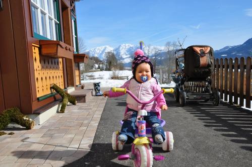 a baby riding a bike on a sidewalk at Bauernhof Haim-Schnepfleitner in Pichl bei Aussee