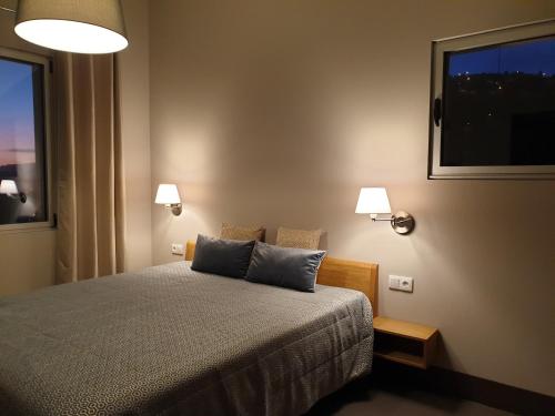 - une chambre avec un lit avec deux oreillers et une fenêtre dans l'établissement Casa Atlantico Dachterrassengeschoss, à Ribeira Brava