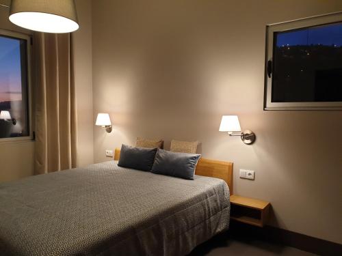 a bedroom with a bed with two pillows and a window at Casa Atlantico Dachterrassengeschoss in Ribeira Brava
