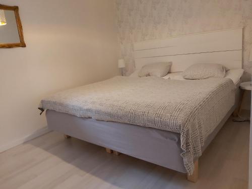 1 dormitorio con 1 cama con colcha blanca en Cottage Langan en Strömstad