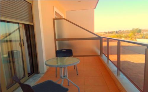 a balcony with a glass table and a chair at Hotel Victoria in Kilkís