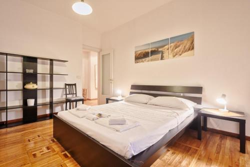 1 dormitorio con 1 cama grande con sábanas blancas en Piazza Statuto Elegant Apartment, en Turín