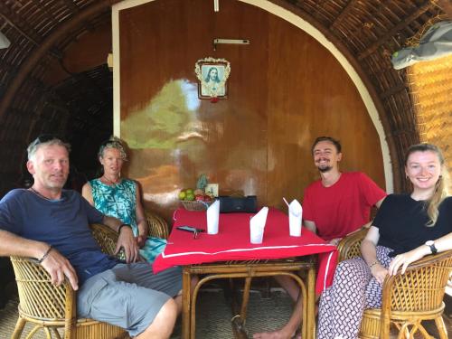 a group of people sitting around a table at Thara's Houseboat in Alleppey