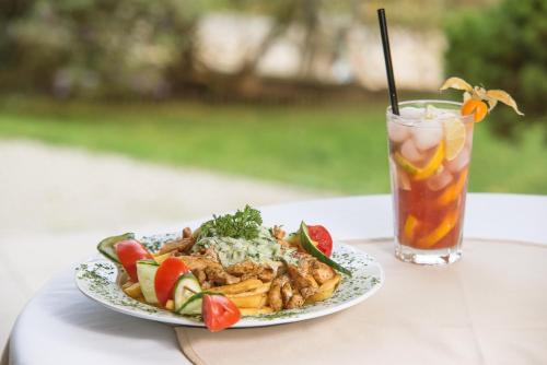 a plate of food on a table with a drink at Regia Panzió in Halászi