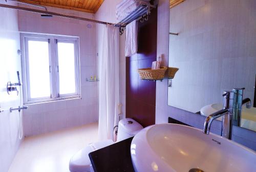 a white bathroom with a sink and a window at Zone Connect by The Park Mount Siniolchu, Gangtok in Gangtok