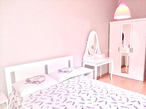 Habitación blanca con cama y espejo en Koza Apartment, next to Akbati Shopping Mall and Tennis court Soul Entertainment, en Estambul