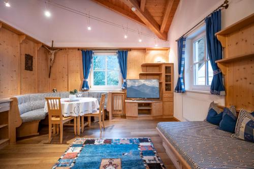 een woonkamer met een tafel en een televisie bij Försterhaus & Haus Andrea in Mayrhofen