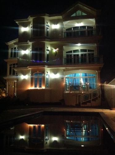 a building with a pool in front of it at night at Luxor Residence Guesthouse in Belle Mare