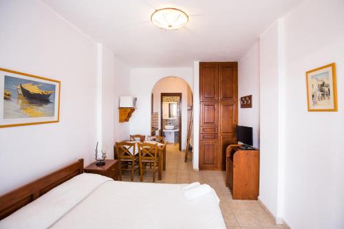 a bedroom with a bed and a dining room at Akrotiri in Analipsi