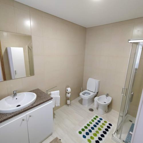 a bathroom with a sink and a toilet and a shower at Helena's House in Ponta Delgada