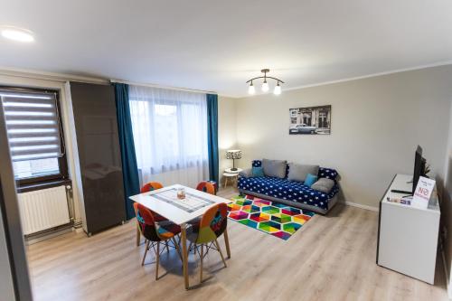 uma sala de estar com uma mesa e um sofá em Travel Homzzz Central Apartments - Tusnad em Târgu-Mureş