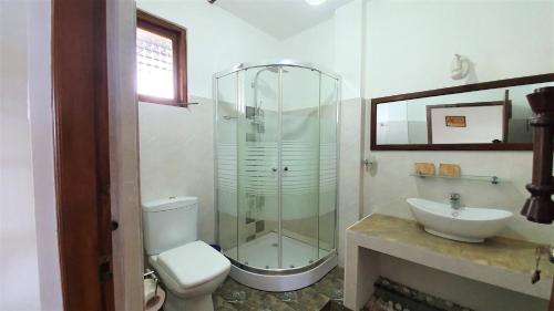 a bathroom with a shower and a toilet and a sink at Dhammika Magic Palace in Wadduwa