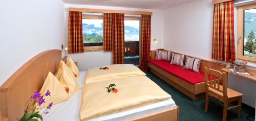 a hotel room with two beds and a bench at Berggasthof Bliembauer in Altenmarkt im Pongau