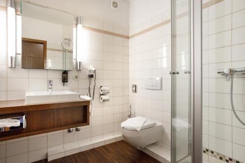 een badkamer met een toilet, een wastafel en een douche bij Hotel Seeschwalbe in Cuxhaven