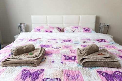 um quarto com uma cama com borboletas rosas e roxas em Travel Homzzz Central Apartments - Tusnad em Târgu-Mureş