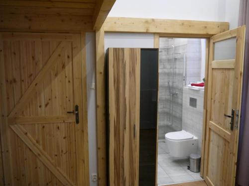 uma casa de banho com uma porta de madeira e um WC em Kamienica Bydgoska 2 em Bydgoszcz