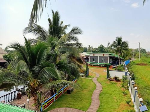 a view from the balcony of a resort with palm trees at บ้านสวนแก้วเฮือนคำ in San Pa Tong