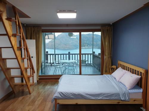 1 dormitorio con escalera, 1 cama y balcón en LaHoya Pension, en Chuncheon