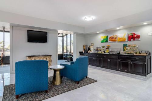 a living room with two blue chairs and a television at Quality Inn McDonough Atlanta South in McDonough