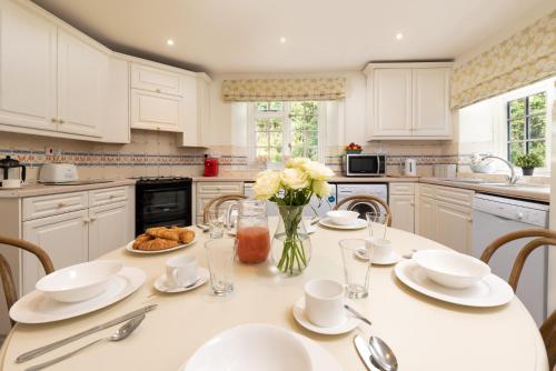 a kitchen with a table with plates and flowers on it at Braunton Farmhouse in Braunton