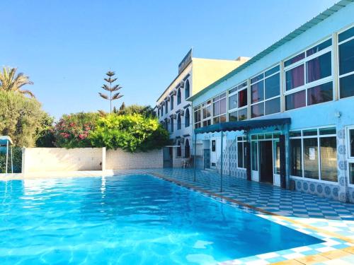 a swimming pool in front of a building at Hotel Ribis in Ait Melloul