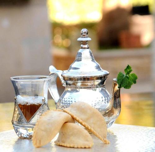 a glass teapot and a bowl of tea and chips at Hotel Ribis in Ait Melloul