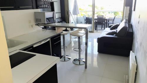 une cuisine avec un comptoir et un salon avec un canapé dans l'établissement Apartment hotel vue mer à 100 mètres des plages étage 5, à Villeneuve-Loubet