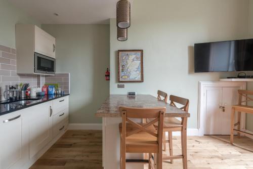 kuchnia ze stołem z krzesłami i blatem w obiekcie Murrayfield Spacious 1 bedroom apartment w Edynburgu
