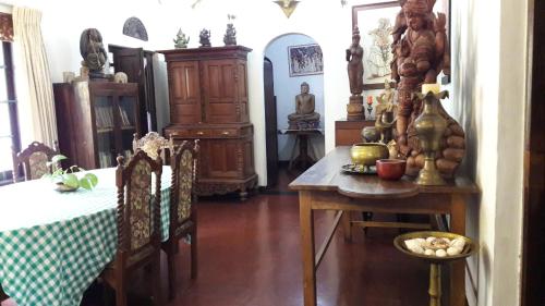 a dining room with a table and a table and chairs at Traditional Kandyan House in Kandy