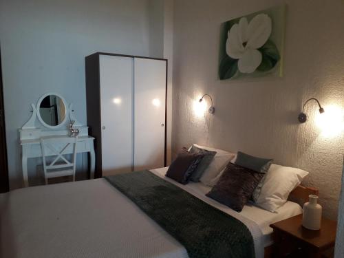 a bedroom with a bed with two pillows and a mirror at Delfin Apartments in Sveti Juraj