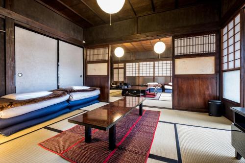 a room with two beds and a table in it at Classic Japan Living Kawamuraya in Fujikawaguchiko