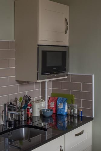 a kitchen counter with a sink and a microwave at Murrayfield Spacious 2-bedroom apartment in Edinburgh
