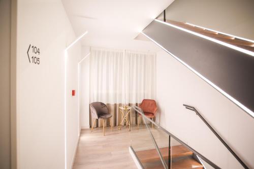 a staircase with two chairs and a table in a room at DWO Ábaster in Soria