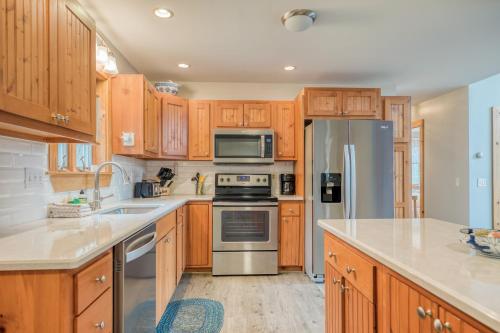a kitchen with wooden cabinets and stainless steel appliances at Cappy's Retreat in Stockton Springs