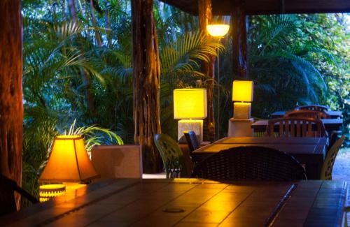a dining room with a table with lamps on it at Lodge Margouillat in Tambor