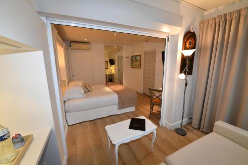 a bedroom with a bed and a table and a couch at Hôtel de Provence in Cannes