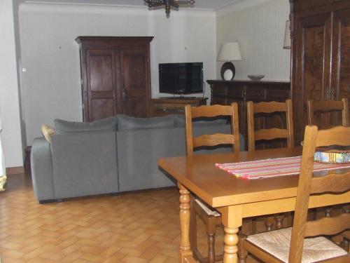 uma sala de estar com um sofá e uma mesa em Gite à la ferme Les places em La Chapelle-Bertrand