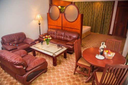 a living room with a couch and a table at Palace Hotel Arusha in Arusha