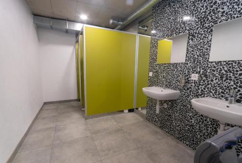 a bathroom with two sinks and a green door at La Ferme des Arêtes in La Chaux-de-Fonds