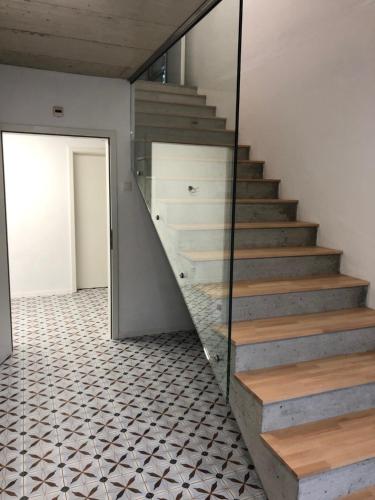a staircase in a house with a glass wall at La Ferme des Arêtes in La Chaux-de-Fonds