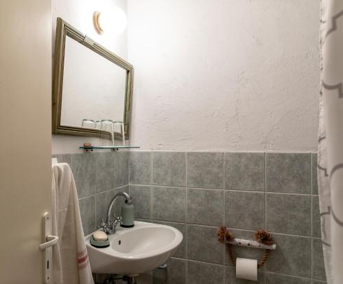 a bathroom with a sink and a mirror at Kanto's Guesthouse in Stemnitsa
