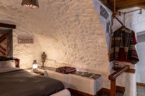 a bedroom with a bed and a stone wall at Kanto's Guesthouse in Stemnitsa