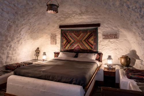 a bedroom with a large bed in a stone wall at Kanto's Guesthouse in Stemnitsa