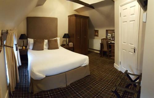 a bedroom with a bed and a desk in a room at The White Hart in Great Yeldham