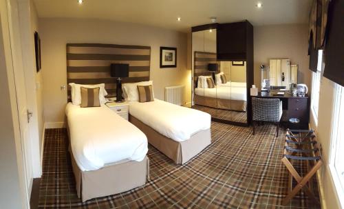 a hotel room with two beds in a room at The White Hart in Great Yeldham