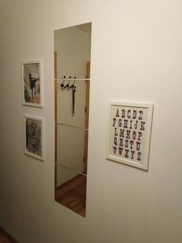 a mirror hanging on a wall next to a refrigerator at Apartament Swarzędz in Swarzędz