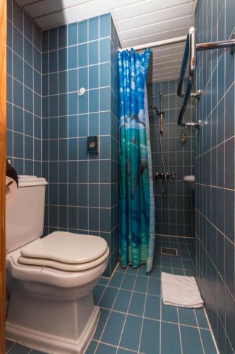 a blue tiled bathroom with a toilet and a shower at Vikerkaare Villa in Tartu